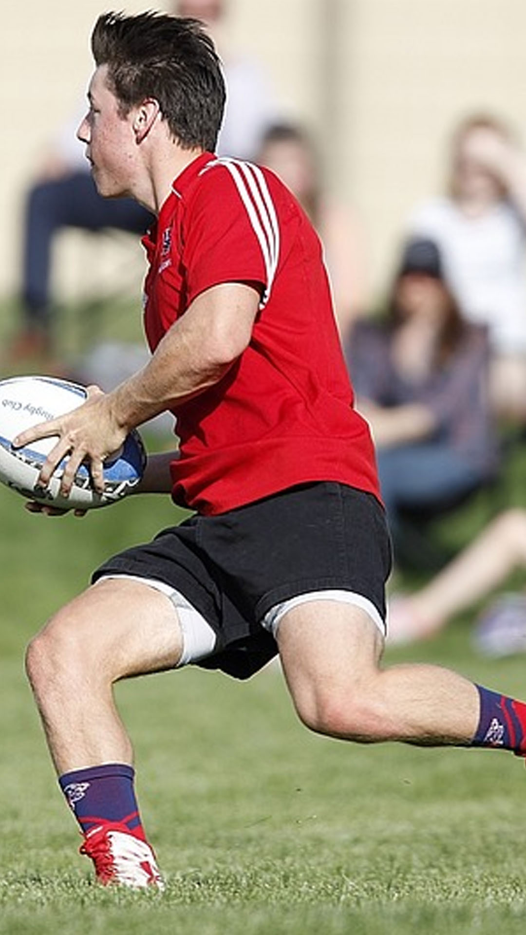 Homme qui joue au rugby et court avec un ballon dans les mains